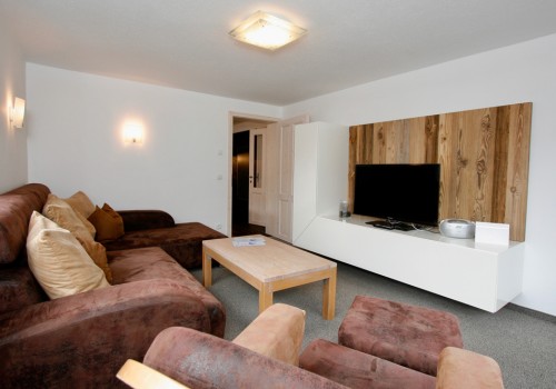 Wohnzimmer mit Flat-TV und Couch