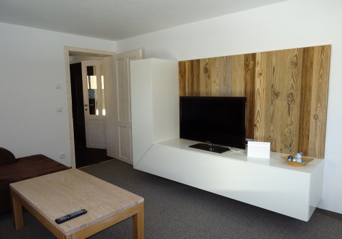 Geräumiges Wohnzimmer mit Couch und Flat-TV